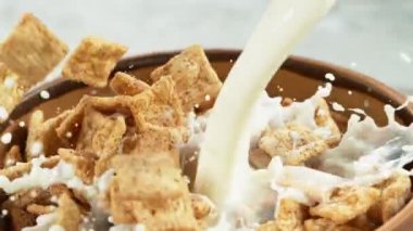 Sütlü gevrek müsli parçalarının düşüşü süper yavaş çekim, kamera hareketi. Yüksek hızlı sinema kamerası, 1000fps.