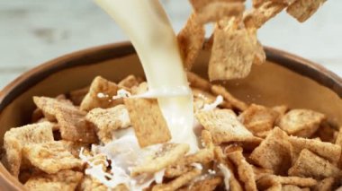 Sütlü gevrek müsli parçalarının düşüşü süper yavaş çekim, kamera hareketi. Yüksek hızlı sinema kamerası, 1000fps.