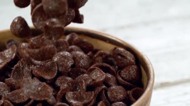 Sütlü gevrek müsli parçalarının düşüşü süper yavaş çekim, kamera hareketi. Yüksek hızlı sinema kamerası, 1000fps.