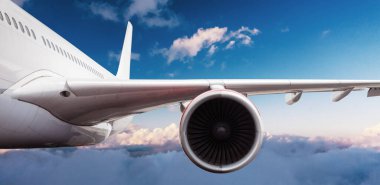 Güzel gün batımı ışığında bulutların üzerinde uçan ticari uçak uçağının kanadının detayları. Seyahat ve iş konsepti