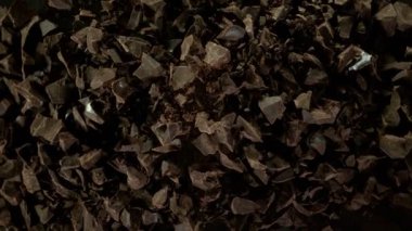 Çiğ çikolata parçalarından oluşan uçan bir grup süper yavaş çekim. Yüksek hızlı sinema kamerası, 1000fps.