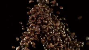 Kahve çekirdeklerinin siyah arka planda çarpışması çok yavaş. Yüksek hızlı sinema kamerası, 1000 fps..