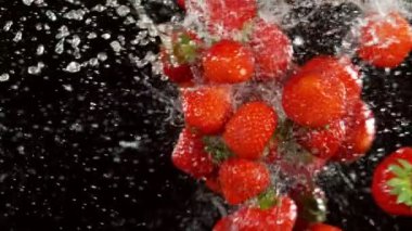 Çileklerin su sıçramalarıyla çarpışması çok yavaş. Yüksek hızlı sinema kamerası, 1000 fps..
