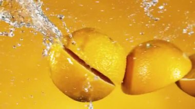 Süper yavaş çekimde portakal dilimleri su sıçramalarıyla çarpışır. Yüksek hızlı sinema kamerası, 1000 fps..