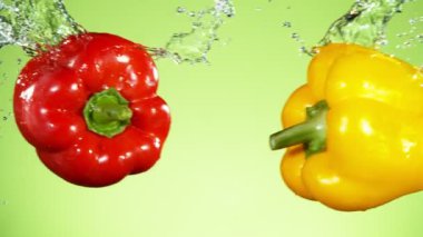 Su sıçramalarıyla havada uçuşan renkli biberlerin süper yavaş çekimi. Yüksek hızlı sinema kamerası, 1000 fps..