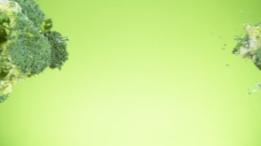 Çok yavaş hareket eden brokoli parçaları havada suyla birlikte uçuyor. Yüksek hızlı sinema kamerası, 1000 fps..