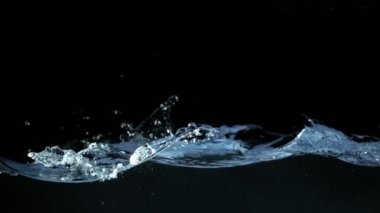 Siyah arka planda izole edilmiş çok yavaş su sıçratma hareketi. Çok hızlı bir kamerayla çekildi, 1000 fps..