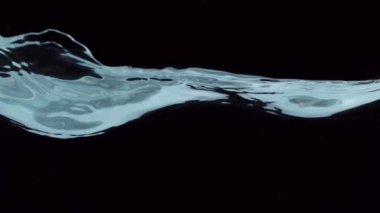Siyah arka planda izole edilmiş çok yavaş hareket eden su dalgaları. Yüksek hızlı sinema kamerası, 1000 fps..