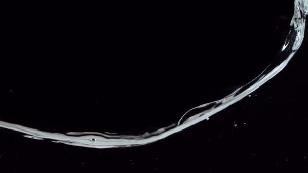 黒の背景に隔離された水を振っての超遅い動き 高速フィルムカメラで撮影しました — ストック動画