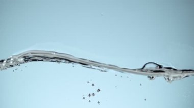 Mavi arka planda izole edilmiş çok yavaş su dalgaları. Yüksek hızlı sinema kamerası, 1000 fps..