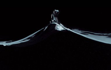 Siyah arkaplanda izole edilmiş su dalgaları, stüdyo makro çekimi.