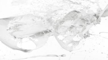 Uçan sütün beyaz arka planda çok yavaş sıçraması. Yüksek hızlı sinema kamerası, 1000 fps..