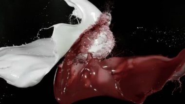 Siyah arka planda sıcak çikolata ve sütün çarpışması çok yavaş oluyor. Yüksek hızlı sinema kamerası, 1000fps.