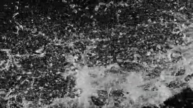 Uçan suyun süper yavaş akımı çarpışma esnasında sıçrar, siyah zemin. Yüksek hızlı sinema kamerası, 1000fps.