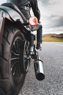 Dağın asfalt yolunda motosiklet süren sürücü, arka tekerlek ayrıntıları, yakın plan.,