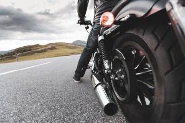 Dağın asfalt yolunda motosiklet süren sürücü, arka tekerlek ayrıntıları, yakın plan.,