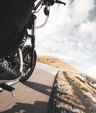 Dağın asfalt yolunda motosiklet sürüyorum. Ön tekerleğin ayrıntıları, yakın plan.,