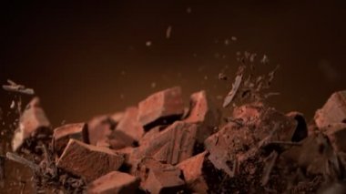 Kakao tozlu çiğ çikolata parçalarından oluşan süper yavaş çekim. Yüksek hızlı sinema kamerası, 1000fps.
