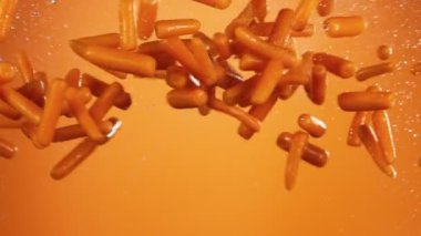 Havada su sıçratarak uçan bebek havuçların süper yavaş çekimi. Yüksek hızlı sinema kamerası, 1000 fps..