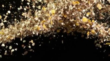 Uçan mısır gevreği müsli grupları havada uçuşurken çok yavaş hareket ediyor. Yüksek hızlı sinema kamerası, 1000fps.