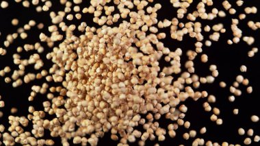 Çiğ bezelye parçaları havada uçuşuyor, siyah arka planda izole edilmiş.