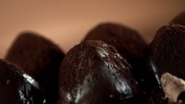 Çikolata kıvırcığının pralinaların üzerine düşmesi çok yavaş bir hareket. Sinema, yüksek hızlı kamera, 1000fps.