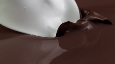 Sıcak çikolata ve sütün çok yavaş bir şekilde dökülmesi. Yüksek hızlı sinema kamerası, 1000fps.
