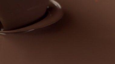Çikolata kıvrımlarının erimiş sıcak çikolataya dönüşmesi süper yavaş bir hareket. Sinema, yüksek hızlı kamera, 1000fps.