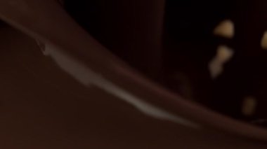 Ezilmiş fındıkların siyah sıcak çikolataya dönüşmesi süper yavaş bir hareket. Sinema, yüksek hızlı kamera, 1000fps.