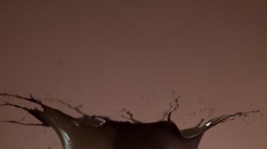 Koyu sıcak çikolatanın çok yavaş sıçratması. Sinema, yüksek hızlı kamera, 1000fps.