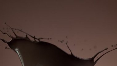 Koyu sıcak çikolatanın çok yavaş sıçratması. Sinema, yüksek hızlı kamera, 1000fps.