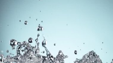 Su sıçratmada süper yavaş çekim, yumuşak mavi arka plan. Yüksek hızlı sinema kamerası, 1000fps.