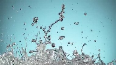 Su sıçratmada süper yavaş çekim, yumuşak mavi arka plan. Yüksek hızlı sinema kamerası, 1000fps.