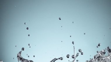 Su sıçratmada süper yavaş çekim, yumuşak mavi arka plan. Yüksek hızlı sinema kamerası, 1000fps.