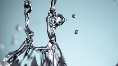 Su sıçratmada süper yavaş çekim, yumuşak mavi arka plan. Yüksek hızlı sinema kamerası, 1000fps.