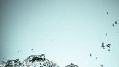 Su sıçratmada süper yavaş çekim, yumuşak mavi arka plan. Yüksek hızlı sinema kamerası, 1000fps.