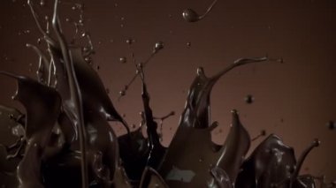 Koyu sıcak çikolatanın çok yavaş sıçratması. Sinema, yüksek hızlı kamera, 1000fps.