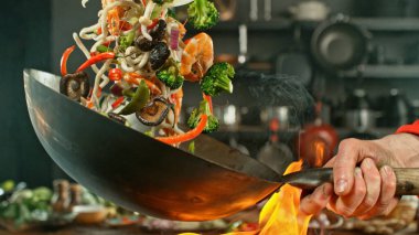 Wok Pan 'ın Dondurucu Hareketi ve Uçan Malzemeler. Arka plandaki Mutfak.