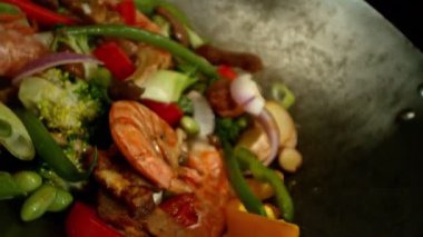 Sebze ve Etli Uçan Asya Yemeklerinin Süper Yavaş Hareketi. Yüksek Hız Sinema Kamerası 'nda çekildi, 600 fps. Kara Arkaplanda İzole Edilmiş, Alevler Yanar.