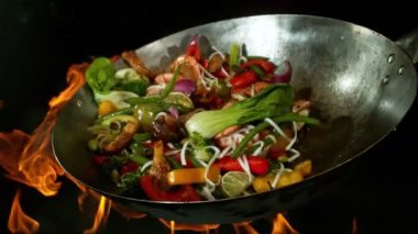 Sebze ve Etli Uçan Asya Yemeklerinin Süper Yavaş Hareketi. Yüksek Hız Sinema Kamerası 'nda çekildi, 600 fps. Kara Arkaplanda İzole Edilmiş, Alevler Yanar.