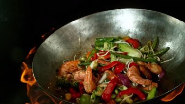 Sebze ve Etli Uçan Asya Yemeklerinin Süper Yavaş Hareketi. Yüksek Hız Sinema Kamerası 'nda çekildi, 600 fps. Kara Arkaplanda İzole Edilmiş, Alevler Yanar.