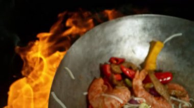 Sebze ve Etli Uçan Asya Yemeklerinin Süper Yavaş Hareketi. Yüksek Hız Sinema Kamerası 'nda çekildi, 600 fps. Kara Arkaplanda İzole Edilmiş, Alevler Yanar.