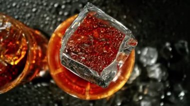 Buz Küpü 'nün Kola İçeceği' ne Düşüşünün Süper Yavaş Hareketi. Yüksek Hız Sinema Kamerası, 1000 fps, Hedef İzleme Kamerası. 