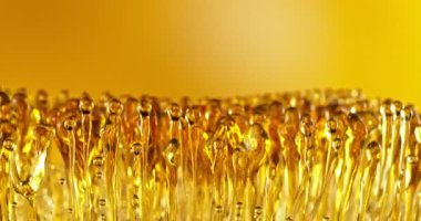 Su Sıçratan Yağ Damlalarının Süper Yavaş Hareketi. Yüksek Hız Sineması Kamerası 'nda çekildi, 1000fps. Soyut Altın Yağ Damlaları, Güzellik veya Aşçılık Konsepti.