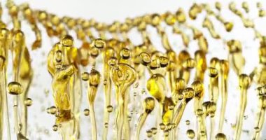 Su Sıçratan Yağ Damlalarının Süper Yavaş Hareketi. Yüksek Hız Sineması Kamerası 'nda çekildi, 1000fps. Soyut Altın Yağ Sıçratma, Güzellik veya Aşçılık Konsepti. Hız Rampası Efekti.