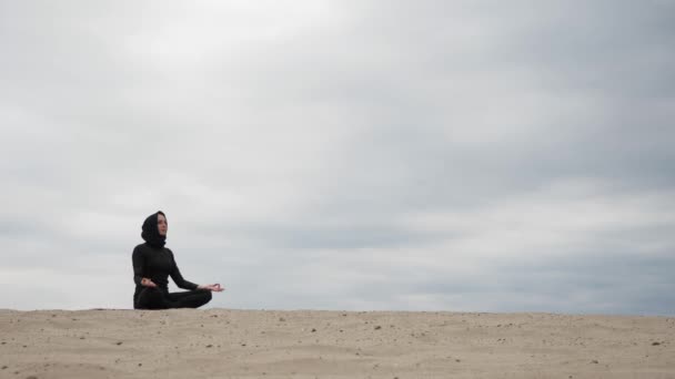 Mujer musulmana en hiyab haciendo ejercicio de yoga estilo de vida saludable en el desierto al atardecer — Vídeo de stock