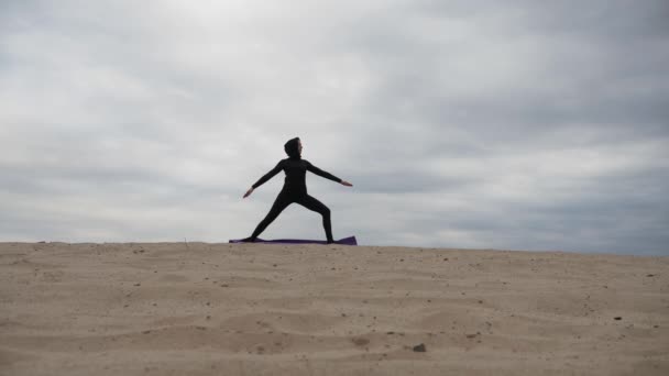 Mulher muçulmana no hijab exercitando exercício de ioga estilo de vida saudável no deserto ao pôr do sol — Vídeo de Stock