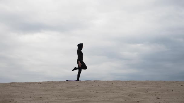 Moslimvrouw in hijab uitoefening van gezonde levensstijl yoga oefening in de woestijn bij zonsondergang — Stockvideo