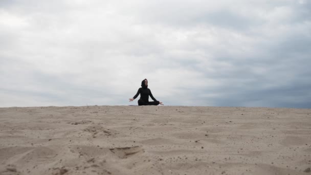 O femeie musulmană în hijab care exercită un stil de viață sănătos exerciții yoga în deșert la apusul soarelui — Videoclip de stoc