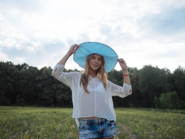 Bahar alan kız gülümseyen güzellik. Çayır. Sağlıklı uzun üfleme saç Enjoying doğa ile gülüyor ve mutlu genç model kadın portresi. Güzel genç kadın açık havada